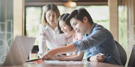 Team of young professional UI graphic designer discussing on their smartphones templates togetherの写真素材
