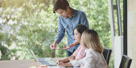 Group of young UI graphic designer discussing on their smartphones templates togetherの写真素材