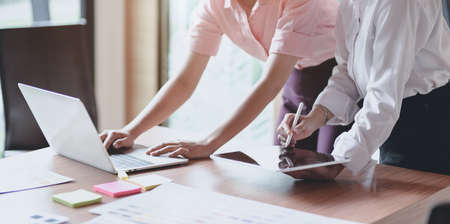 Professional UI graphic designer discussing on their smartphones templates while using tablet and laptopの写真素材