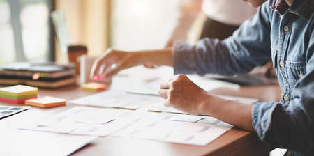 UX web designer planing the idea on smartphone application together in modern office roomの写真素材