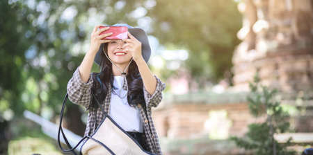 Young asian traveler taking the photo of the old temple while visiting the ancient historical places during the vacationの写真素材