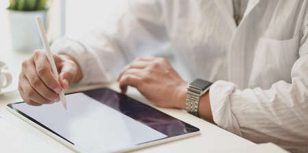 Close-up view of passionate freelancer planing his idea concept on tablet in his modern office roomの写真素材