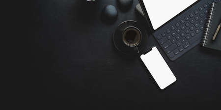 Dark modern workplace with tablet and office supplies on black leather background with copy spaceの写真素材