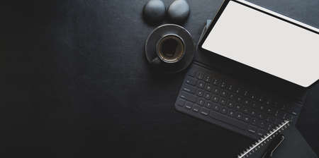 Dark modern workplace with tablet and office supplies on black leather background with copy spaceの写真素材