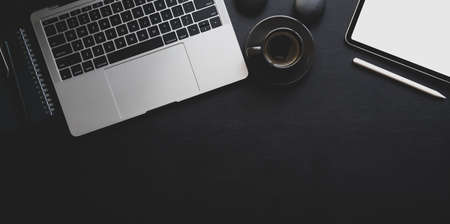 Dark luxury workplace with copy space laptop computer and office supplies on black leather backgroundの写真素材