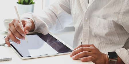 Cropped shot of businessman writing his idea concept on tablet for his upcoming project in modern office roomの写真素材