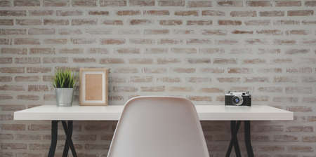 Loft modern workplace with white wooden table with office supplies and copy space with brick wall backgroundの写真素材