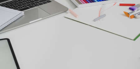 Comfortable workplace with stationery and laptop computer on white wooden table with copy spaceの写真素材