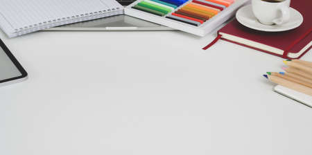 Modern workplace with stationery and painting tools on white wooden table with copy spaceの写真素材