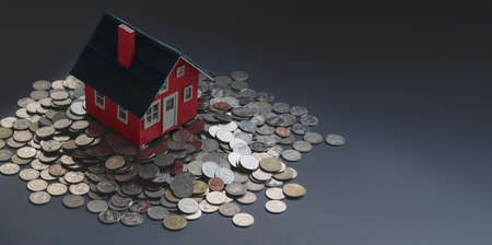 Red small house model on stack of coins with black background, real estate and property investment conceptの写真素材
