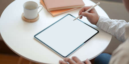 Close-up view of male freelancer writing his idea concept on blank screen tablet in modern workplaceの写真素材