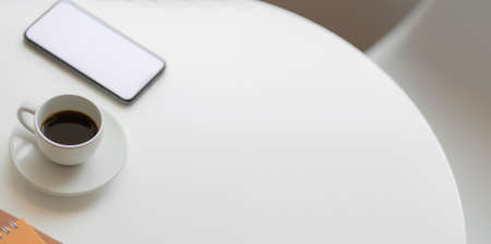 Cropped shot of comfortable workspace with copy space and coffee cup on white wooden tableの写真素材