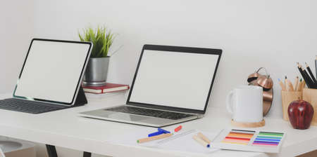 Back to school concept : Blank screen laptop computer and tablet with stationary and decorations on modern workplaceの写真素材
