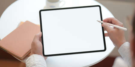 Close-up view of professional businessman writing his idea concept on blank screen tablet in modern workplaceの写真素材