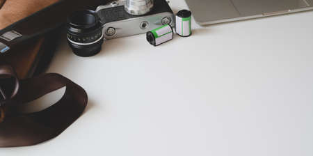 Cropped shot of modern photographer with copy space and office supplies on white wooden table backgroundの写真素材