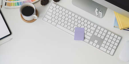 Top view of modern workplace with keyboard computer and office supplies on white table background...