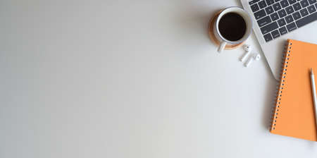 Overhead shot of comfortable workplace with notebook on white desk background with office accessoriesの写真素材