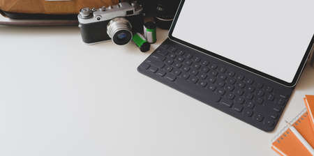 Modern workplace with blank screen tablet with camera and office supplies in photographer workplaceの写真素材
