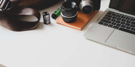 Cropped shot of modern photographer workplace with laptop computer and office suppliesの写真素材