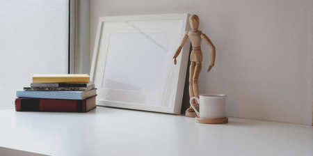 Minimal workspace with mock up frame and copy space with decorations on white wooden tableの写真素材