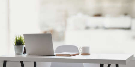 Comfortable workplace with laptop computer, coffee cup and office supplies with the relaxing atmosphereの写真素材