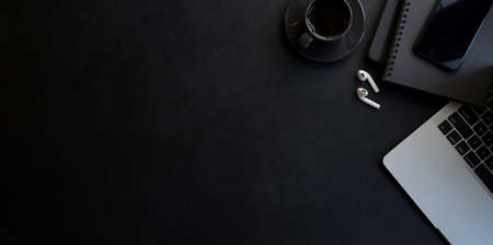 Modern workplace with dark luxury style with copy space and office supplies on black leather desk backgroundの写真素材