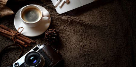 Close-up view of dark brown retro workplace with copy space, coffee cup and office supplies on brown fur backgroundの写真素材