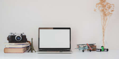 Minimal workplace with open blank screen laptop computer, camera and office suppliesの写真素材
