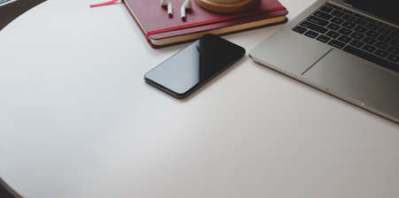 Cropped shot of contemporary workplace with copy space and office supplies on white wooden deskの写真素材