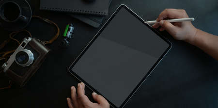 Top view of young man working on his project with tablet in dark luxury workspaceの写真素材