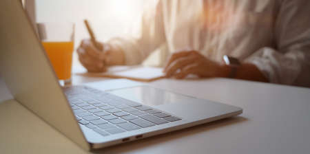 Cropped shot of businessman working on his project while using laptop computer in his comfortable office roomの写真素材