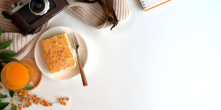 Top view of cozy workspace with a glass of orange juice and toast bread on white wooden tableの写真素材