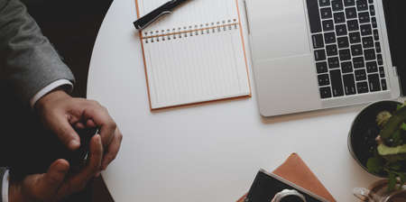 Cropped of professional businessman working on his project with laptop computer while holding coffee cupの写真素材