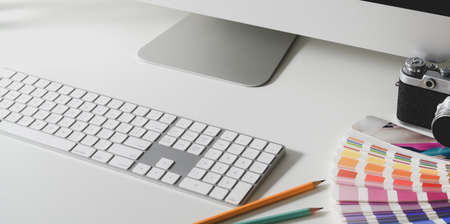 Cropped shot of modern designer workspace with keyboard computer and colour swatches on white tableの写真素材
