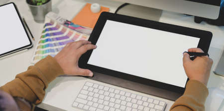 Close-up view of professional male designer working on his project on blank screen digital tablet の写真素材