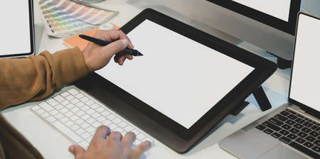 Close-up view of male designer editing his project on blank screen digital tablet in his comfortable workplaceの写真素材