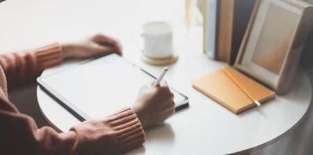 Cropped shot of young female freelancer working on her upcoming project while editing on blank screen tabletの写真素材