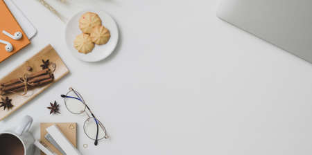 Top view of autumn workplace with copy space, office supplies and decorations on white desk backgroundの写真素材