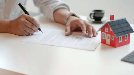 Close-up view of customer signing contract about home loan agreement, property real estate conceptの写真素材
