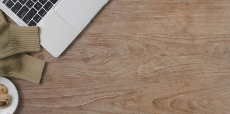 Top view of comfortable workspace with copy space and laptop computer on wooden table background の写真素材