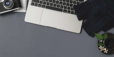 Overhead shot of winter workspace with laptop computer and office supplies on grey desk backgroundの写真素材