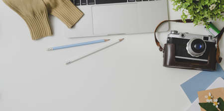 Top view of photographer comfortable workspace with office supplies on white table background with camera の写真素材