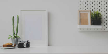 Comfortable workplace with mock up frame and copy space with camera and office supplies の写真素材