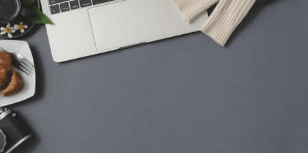Top view of winter workspace with laptop computer and office supplies on grey desk backgroundの写真素材