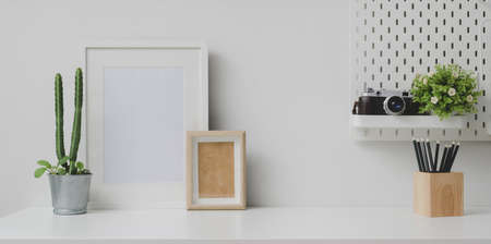 Comfortable workplace with mock up frame and copy space with camera and office supplies の写真素材