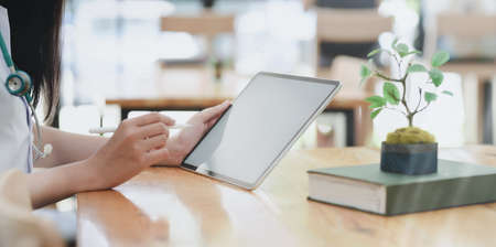 Close-up view of young professional female doctor summarise her chart at her workspace