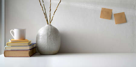 Minimal workspace with copy space and ceramic vase decorations on white table and white wall background の写真素材
