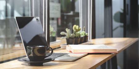 Comfortable co-working space with open laptop computer and document with decorations 