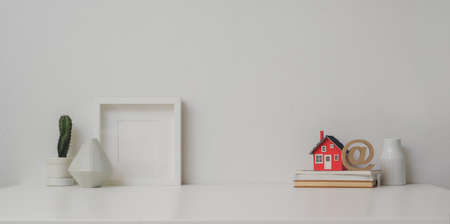 Minimal workspace with mock up frame and copy space on white table and decorationsの写真素材