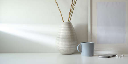 Minimal workspace with copy space and ceramic vase decorations and mock up frame の写真素材